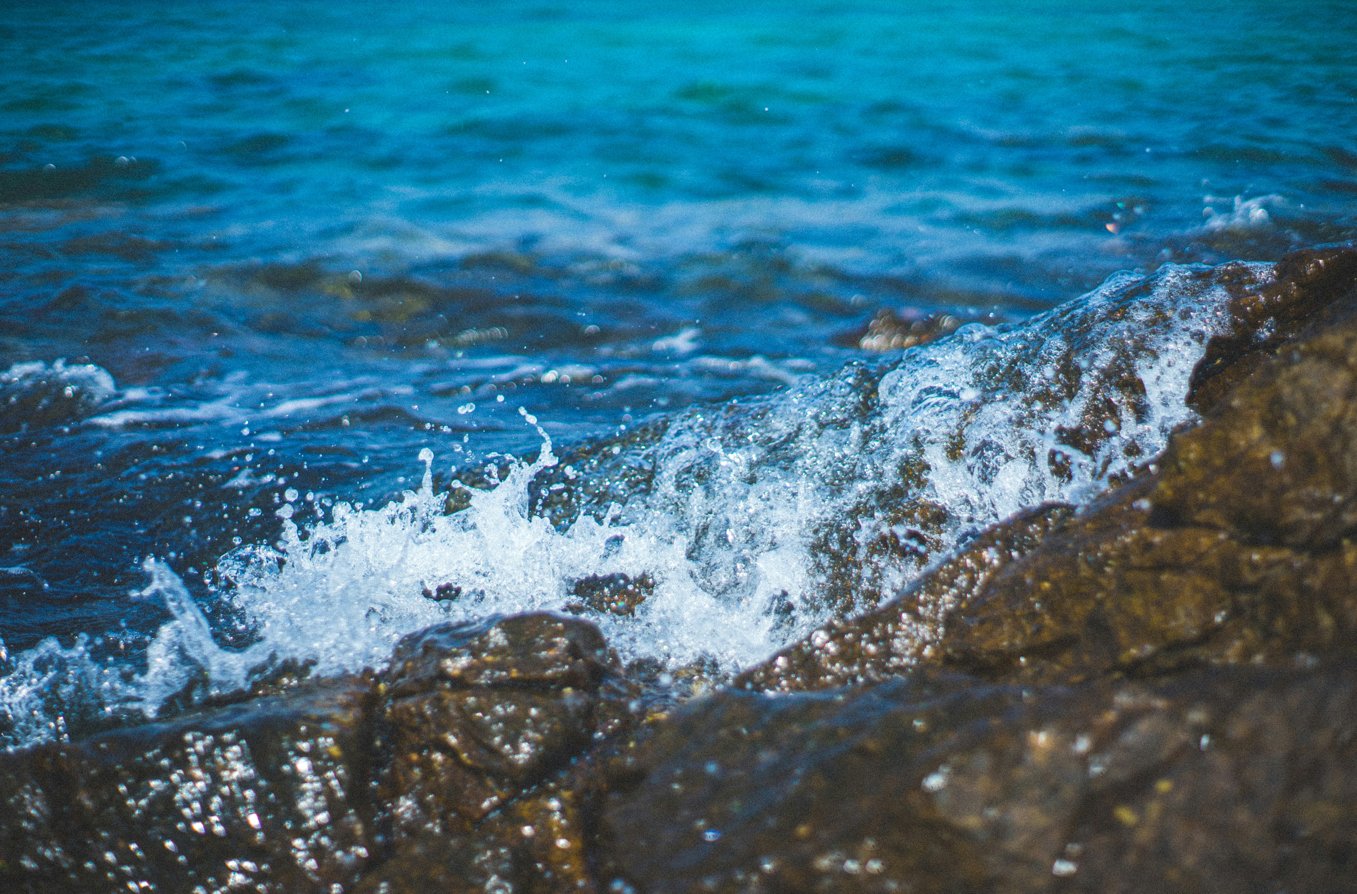 water waves hitting brown rocks